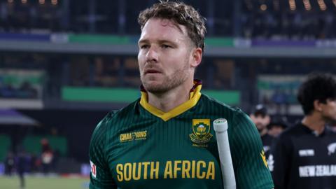 David Miller walks off with a bat under his arm