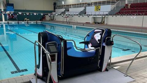 a platform lift at the end of a swimming pool lane for lifting disabled people into the water