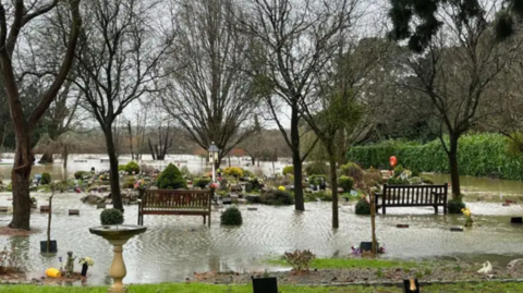 Randalls Park Crematorium cemetery in Leatherhead pictured during extreme flooding earlier this month. Elevated water levels can be seen in the cemetery, where some headstones are partly underneath. 