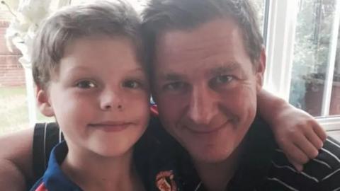 Fraser and Stuart Bates hugging and smiling at the camera