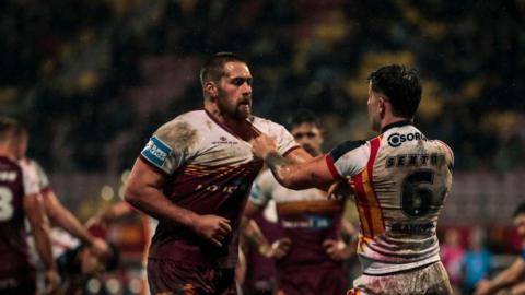 Huddersfield's Sam Hewitt and Catalans' Toby Sexton confront each other, grabbing shirt collars