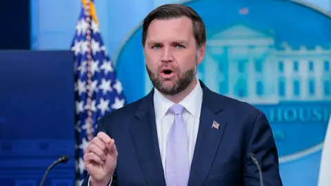 JD Vance speaking at the lectern in the White House briefing room