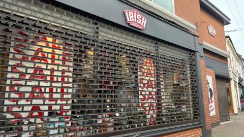 The shuttered front of Irish Menswear in Loughborough