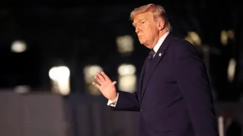 Trump waves with his right hand