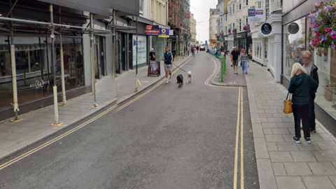 A google street view picture of East Street, a narrow road with shops all the way down on either side.