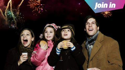 A family watch a firework display.