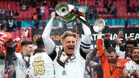 Byron Webster lifts the National League promotion final trophy