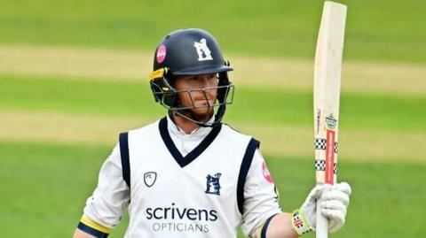 Alex Davies raises his bat to the crowd 