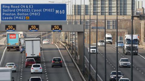 M60 cars and lorries on the northbound carriageway near junction for M602 eastbound and M62 westbound.