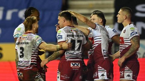 Wigan players congratulate number 17 Oli Partington on scoring a try against Leigh Leopards 