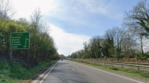 Dual carriageway with road sign to the left.