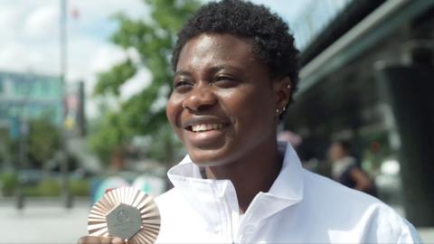 Mariam smiling holding her medal