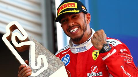Lewis Hamilton celebrates with the trophy after winning the Barcelona-Catalunya Grand Prix
