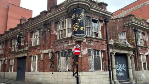 The graffiti-covered front of the Black Boy pub