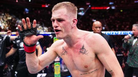 Ian Machado Garry celebrates in the octagon after a fight