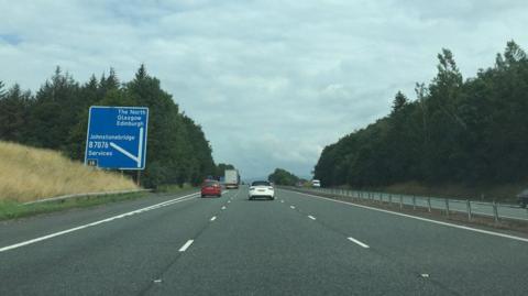 The A74(M) motorway with a few cars on it and a sign for Glasgow and the North and Johnstonebridge services