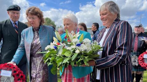 Families of Maj John Howard and Lt Den Brotheridge laying wreaths and flowers at the memorial site at Pegasus Bridge