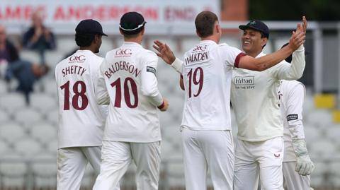 Ben Walkden (WALKDEN 19) is congratulated on his first Lancashire wicket 