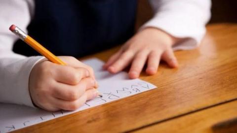 The hands of a child writing the alphabet