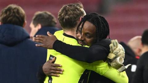 Niall Ennis is hugged by Stoke goalkeeper Viktor Johansson 