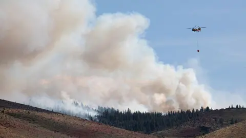  A firefighting helicopter responds to the Hawk Fire.