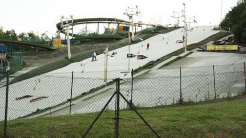 A general view picture of the ski slope, with fences in front of it.