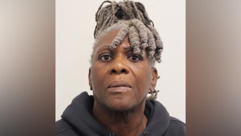 A mugshot of a Janice Nix against a plain background. She is wearing a dark grey hooded sweatshirt. 