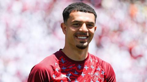 A smiling Zeki Amdouni in Switzerland's red training kit