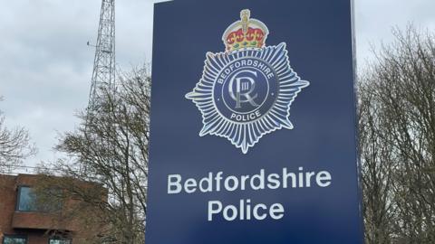 A blue Bedfordshire Police sign outside their headquarters
