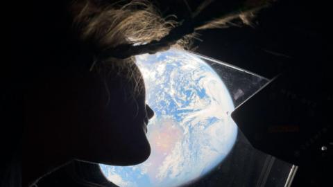 Astronaut Christina Koch watching Earth from the Orion spacecraft
