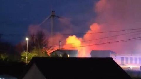 A plume of white smoke coming off a glowing orange ball in the background.