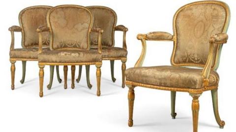 A picture of four green painted, padded chairs made by Thomas Chippendale. 