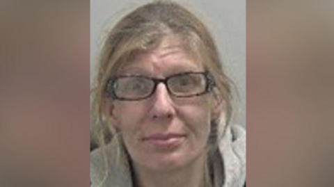 A woman with brown hair is in a portrait-shaped image in the middle of the photo. She is wearing dark glasses and a grey top.