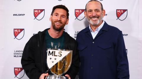 Lionel Messi holding his MLS Most Valuable Player award alongside MLS Commissioner Don Garber.