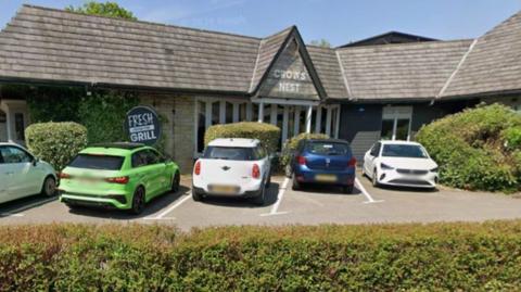 The Crow's Nest Pub exterior with cars parked in the car park in front of the entrance.