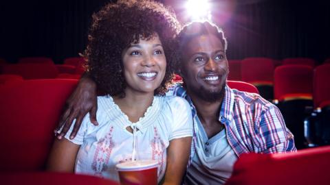 A couple watch a movie in an empty cinema