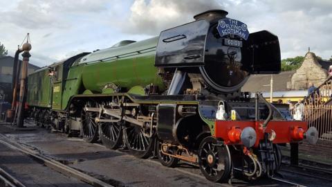 The Flying Scotsman locomotive, black at the front, then green in colour, goes from left to right on the photo.