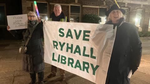 Protestors with banner that reads: 'Save Ryhall Library'