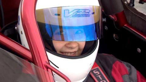 Candra sat in her car wearing a helmet, the open visor covering her eyes