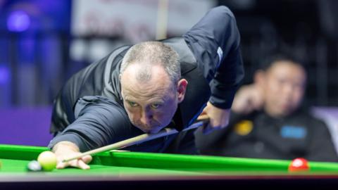 Mark Williams prepares to take a shot at the Wuhan Open