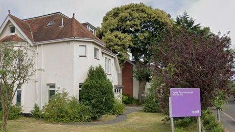 A general view of the clinic, a three-storey building with rendered, white walls.