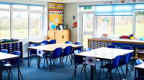 Tidy tables and chairs arranged in school class room, ready for pupils to arrive