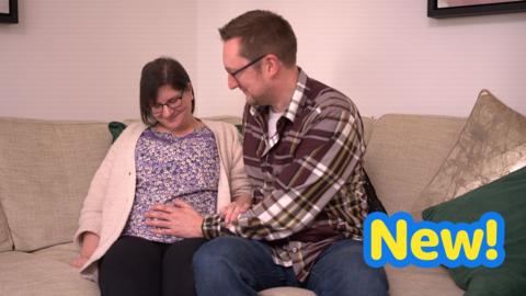 Dad placing hand on mum's baby-bump