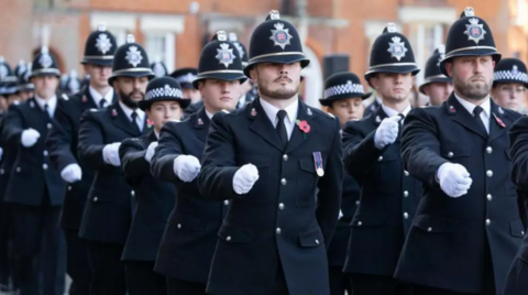 A group of Essex Police officers in uniforms marching. They appear to be outside the force's headquarters