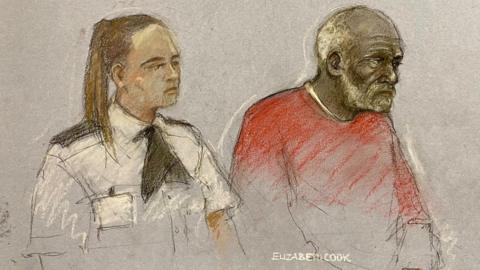 Court drawing of Ryland Headley, who is wearing a red top and has receeding white hair and a beard, sitting next to a female police officer in uniform with her hair tied into a pony tail.
