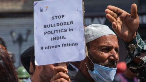 SRINAGAR, JAMMU AND KASHMIR, INDIA - 2022/06/17: Kashmiri man holds a placard expressing his opinion during a demonstration. Indian authorities demolished the house of young Muslim activist Afreen Fatima and his father Javeed Mohammad who was arrested in northern Indian state of Uttar Pradesh for allegedly being the "mastermind" behind the recent violent religious protests over blasphemous comments on Prophet Muhammad (PBUH) by India's Hindu nationalist ruling party's suspended spokeswoman Nupur Sharma and expelled leader Naveen Jindal. Protests have been erupting in many Indian cities to condemn the demolition of homes and businesses belonging to Muslims, in what critics call a growing pattern of "bulldozer justice" aimed at punishing activists from the minority group. (Photo by Faisal Bashir/SOPA Images/LightRocket via Getty Images)