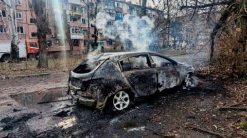 A burning car is seen in front of an apartment building damaged by a Russian missile strike, amid Russia's attack on Ukraine, in Kryvyi Rih,