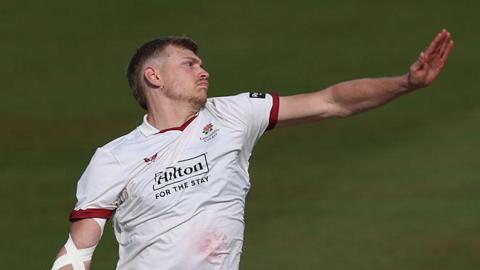 A side-on shot of Mitch Stanley bowling for Lancashire in the Championship