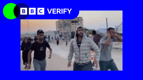 Gazans running after the Israeli strike on Khan Younis. Three men can be seen in the image. One man is wearing a grey jacket, the others are wearing t-shirts. A damaged building can be seen in the image. 