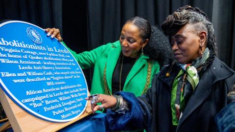 Councillor Abigail Marshall Katung, Lord Mayor of Leeds, and poet Khadijah Ibrahim observe the "Abolitionists in Leeds" plaque